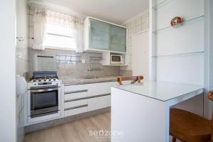 a kitchen with white cabinets and a stove top oven at Apt 2 Bedrooms w/ Air in Floripa CIS0033 in Florianópolis