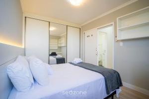 a bedroom with a white bed with white pillows at Apt 2 Bedrooms w/ Air in Floripa CIS0033 in Florianópolis