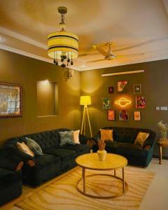 una sala de estar con un sofá y una mesa en The Golden Suite, en Islamabad