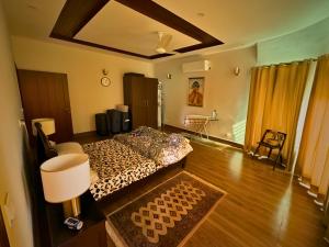 Un dormitorio con una cama y suelo de madera. en The Golden Suite, en Islamabad