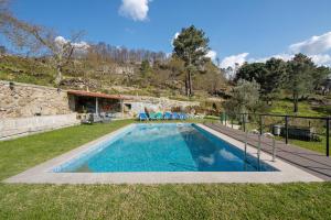 einen Pool mit blauen Stühlen im Hof in der Unterkunft Quintinha De Pinouco in Miomães
