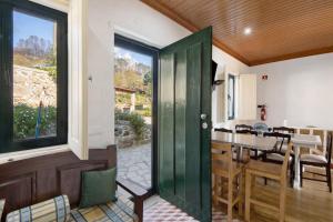eine grüne Tür, die zu einer Küche und einem Esszimmer führt in der Unterkunft Quintinha De Pinouco in Miomães