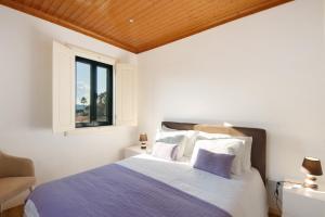 ein Schlafzimmer mit einem Bett und einem Fenster in der Unterkunft Quintinha De Pinouco in Miomães + 37 Fotos