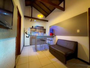 un salon avec un canapé et une cuisine dans l'établissement Pousada Kauai, à Imbituba