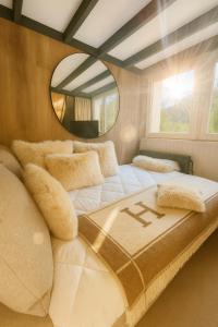 - un grand lit dans une chambre avec un miroir dans l'établissement Ma Montagne Chic 4, à La Bresse