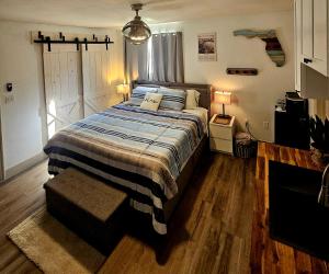 a bedroom with a bed with a blue and white blanket at 10 Minutes from Universal - Relaxing Guest Suite in Orlando