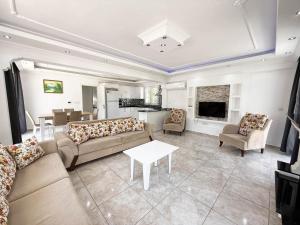 un ampio soggiorno con divani e un tavolo di Villa Fergana a Ovacik