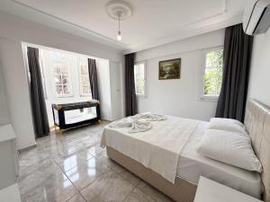 una camera bianca con un letto e un pianoforte di Villa Fergana a Ovacik Altre 22 foto