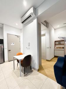 Lucentia Residences Kuala Lumpur By Luxury Suites BBCC في كوالالمبور: غرفة بها طاولة وكراسي ومطبخ