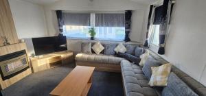 a living room with a couch and a flat screen tv at Terri Towers in Stevenston