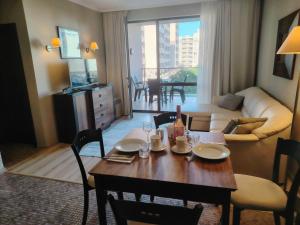 a living room with a table with chairs and a couch at Apartment in Hotel Royal Beach 5 Pool View in Sunny Beach