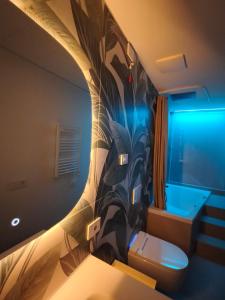 ein Badezimmer mit Toilette und Wandgemälde in der Unterkunft Luxury apartment Porta Romana, Bocconi and city center in Mailand