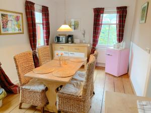 Ferienwohnung und Pension Goldberg في غروسشوناو: غرفة طعام مع طاولة وكراسي من الخيزران