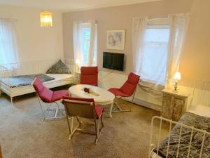 Ferienwohnung und Pension Goldberg في غروسشوناو: غرفة معيشة بها سرير وطاولة وكراسي