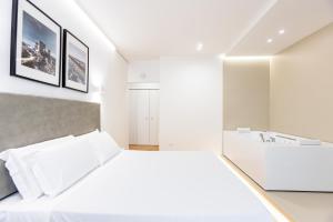 a white bedroom with a bed and a sink at Centoquindici Rooms & Suite in Montesilvano