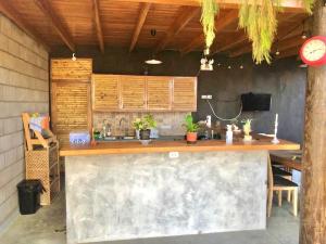 an outdoor kitchen with a counter and a table at Casa Kahuna in Canoas de Punta Sal