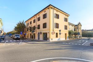 un edificio amarillo en la esquina de una calle en Residence Brugnano, en Cremona