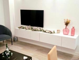 soggiorno con TV su un armadio bianco di Moderno apartamento con garaje privado en el centro de Vigo a Vigo