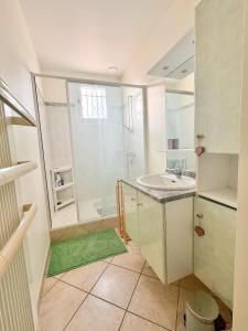 a white bathroom with a sink and a shower at Maison le 21B au coeur de Lesconil in Plobannalec-Lesconil
