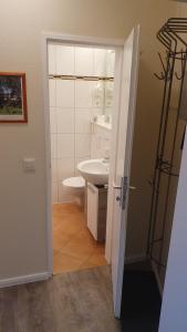 une salle de bain avec un lavabo blanc et des toilettes dans l'établissement Küstenoase, à Cuxhaven