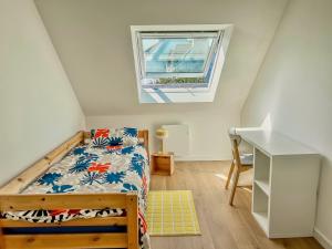 a bedroom with a bed and a desk and a window at Maison le 21B au coeur de Lesconil in Plobannalec-Lesconil