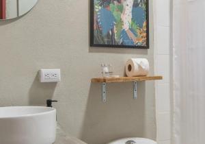 baño con aseo y estante con papel higiénico en Monteverde The Lodge, en Monteverde 12 fotos más