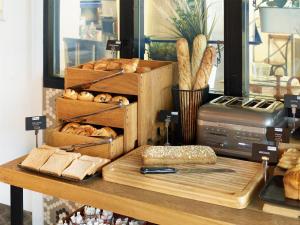 Una mesa con un poco de pan y una tabla de cortar con pan. en Radisson Hôtel Bordeaux Saint-Jean, en Burdeos 24 fotos más