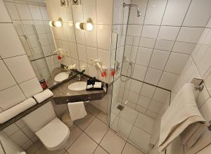 a bathroom with a shower and a toilet and a sink at Hotel Santoni in Guarapuava +32 photos