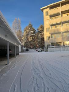 un parcheggio coperto di neve di fronte a un edificio di Keisari Apartment a Rovaniemi