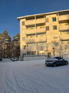 un'auto parcheggiata davanti a un grande edificio di Keisari Apartment a Rovaniemi Altre 10 foto