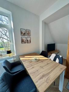 Una sala de estar con una mesa y sillas de madera. en Robbe beim Ochsenturm am Deich, 