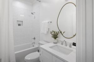 a white bathroom with a sink and a toilet and a mirror at Weekend Escape on the Coast-Relax & Unwind in Pass Christian +21 photos