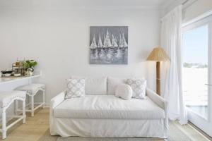 a white couch in a living room with a picture of sailboats at Weekend Escape on the Coast-Relax & Unwind in Pass Christian