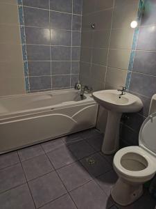 Un baño con bañera, inodoro y lavabo. en Apartament 1 cameră, en Bragadiru