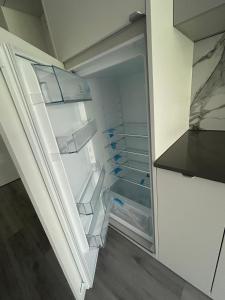 an empty refrigerator with its door open in a kitchen at Sea and lake apartament in Mielno