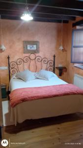 a bed with white sheets and a red blanket at La Portiella del Llosu in Pandiello