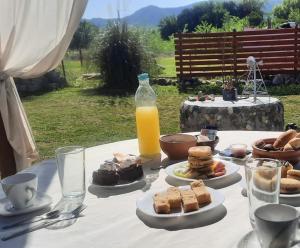 ein Tisch mit Tellern voller Essen und einer Flasche Orangensaft in der Unterkunft CabañaPaz in Santa Rosa de Calamuchita + 10 Fotos