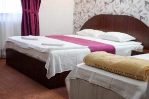two beds in a hotel room with two at Hotel Poem Calarasi Ballroom in Călăraşi