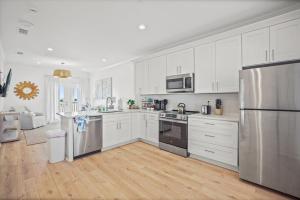 a kitchen with white cabinets and stainless steel appliances at Quiet Harbor Condo-Private Balcony-Relaxing Stay in Pass Christian