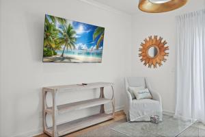 a living room with a table and a chair and a mirror at Quiet Harbor Condo-Private Balcony-Relaxing Stay in Pass Christian