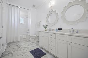 a white bathroom with a sink and a mirror at Quiet Harbor Condo-Private Balcony-Relaxing Stay in Pass Christian +31 photos