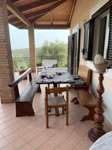 a patio with a table and chairs on a porch at Pink House in Perdifumo