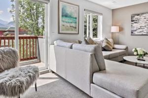 a living room with a couch and a balcony at Rockies 3BR Townhome w Stunning Views Near DT in Canmore