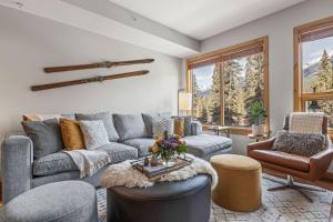 a living room with a couch and a table at 2BR Modern Luxe Condo with Hot Tub and Views in Canmore