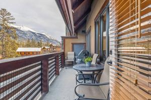a balcony with a table and a view of a mountain at 2BR Modern Luxe Condo with Hot Tub and Views in Canmore