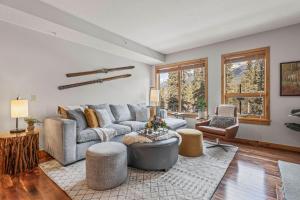 a living room with a couch and a table at 2BR Modern Luxe Condo with Hot Tub and Views in Canmore