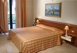 a hotel room with a bed and a picture on the wall at Residence Spiaggia D'Oro in Desenzano del Garda