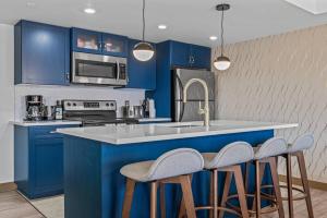 a kitchen with blue cabinets and a sink and stools at Free Arcade Delightful Stay in Rocky Mountains in Dead Man's Flats