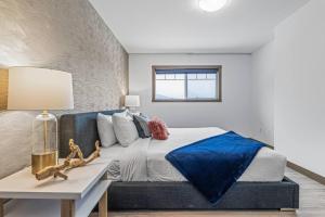 a bedroom with a bed with a blue blanket on it at Free Arcade Delightful Stay in Rocky Mountains in Dead Man's Flats