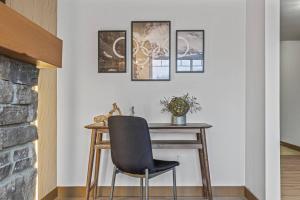 a desk with a chair next to a wall with pictures at Free Arcade Delightful Stay in Rocky Mountains in Dead Man's Flats +36 photos